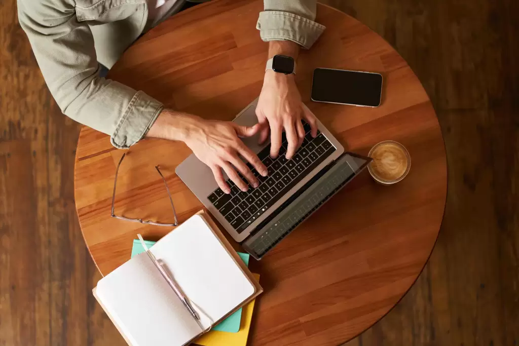 Pessoa digitando em laptop em ambiente de trabalho moderno, representando o uso de copywriting em campanhas de marketing.