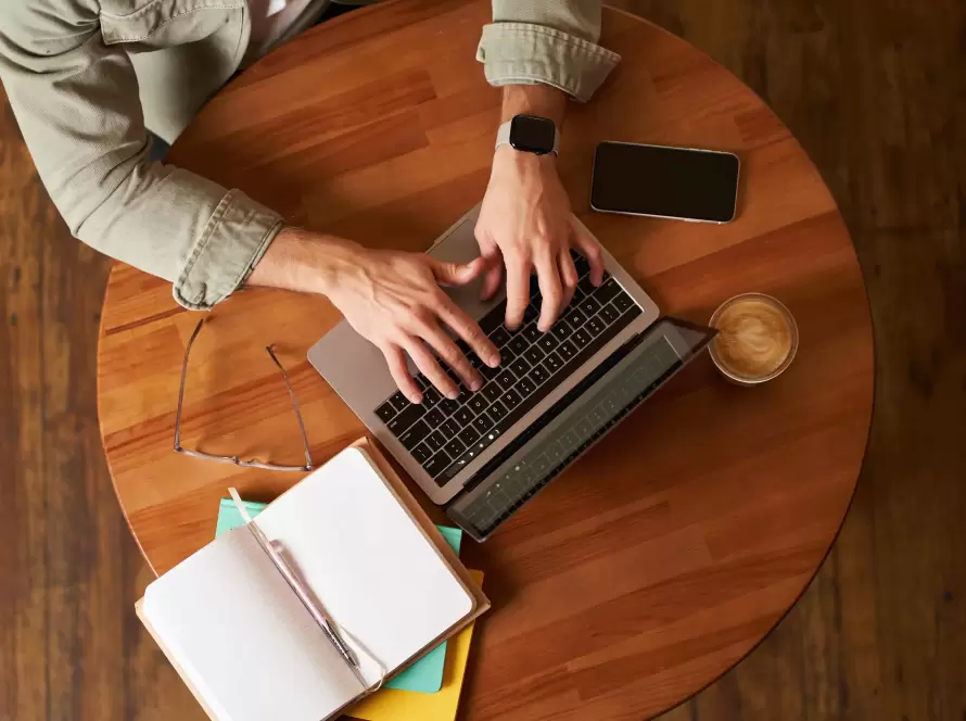 Pessoa digitando em laptop em ambiente de trabalho moderno, representando o uso de copywriting em campanhas de marketing.