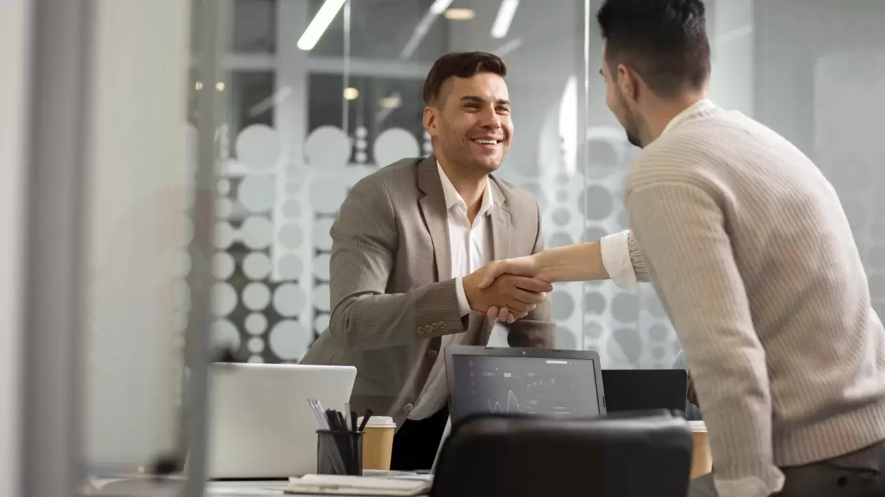 Profissional e cliente em reunião de negócios apertando as mãos, simbolizando processo de pré-vendas.