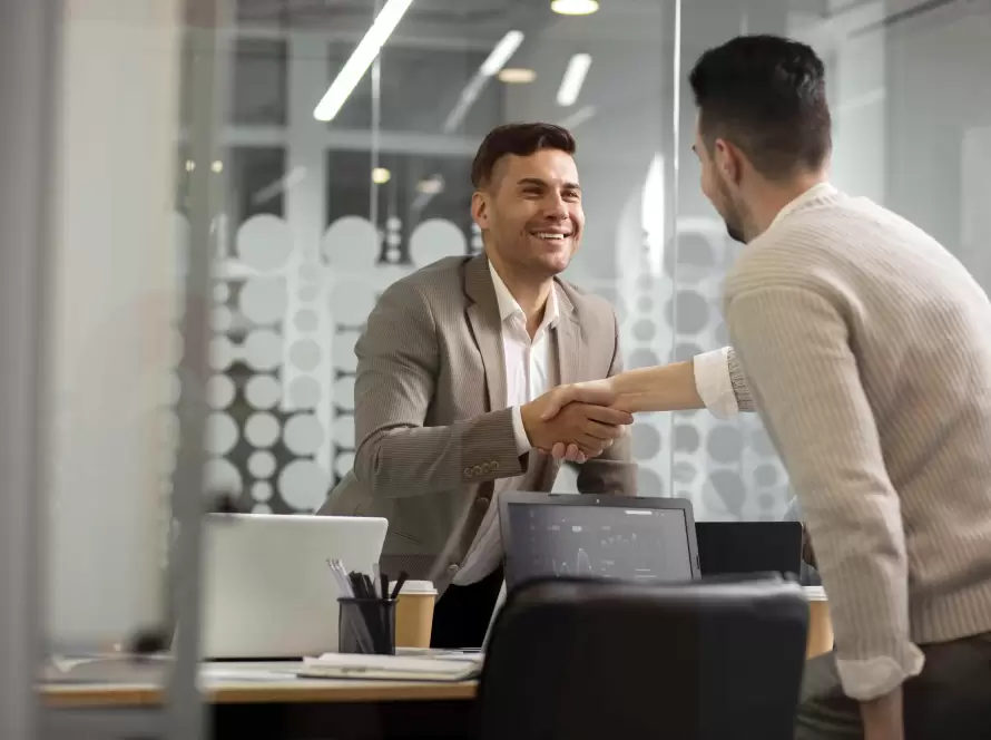 Profissional e cliente em reunião de negócios apertando as mãos, simbolizando processo de pré-vendas.