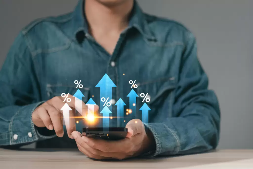 Pessoa utilizando smartphone com gráficos de crescimento, representando aumento da taxa de conversão em estratégias digitais.