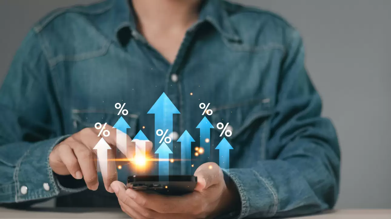 Pessoa utilizando smartphone com gráficos de crescimento, representando aumento da taxa de conversão em estratégias digitais.