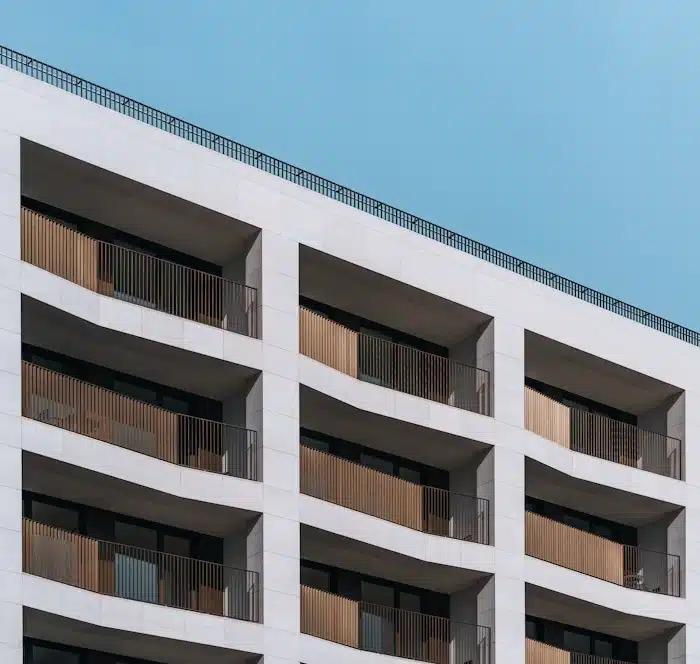 Fachada de um edifício residencial moderno com varandas de madeira brise-soleil e céu azul claro, ilustrando o resultado de um empreendimento que seguiu uma estratégia de Lançamento-Imobiliário-eliminar-riscos-antes-das-vendas.