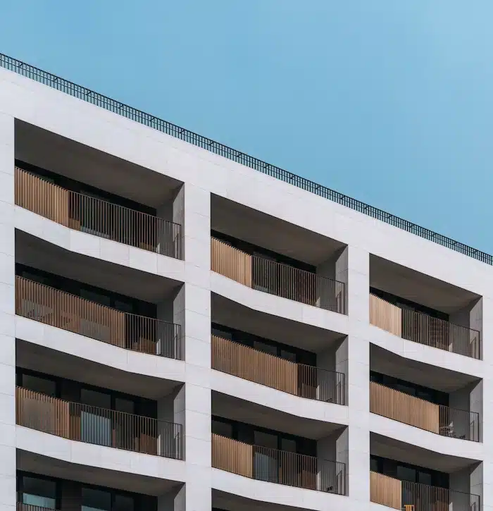 Fachada de um edifício residencial moderno com varandas de madeira brise-soleil e céu azul claro, ilustrando o resultado de um empreendimento que seguiu uma estratégia de Lançamento-Imobiliário-eliminar-riscos-antes-das-vendas.