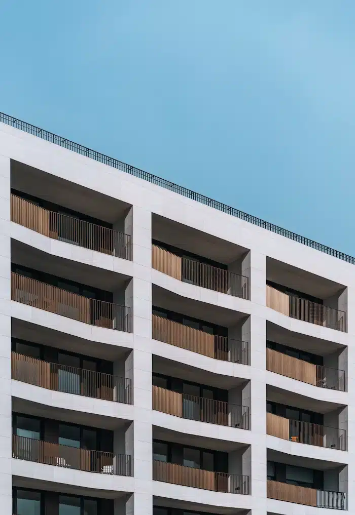 Fachada de um edifício residencial moderno com varandas de madeira brise-soleil e céu azul claro, ilustrando o resultado de um empreendimento que seguiu uma estratégia de Lançamento-Imobiliário-eliminar-riscos-antes-das-vendas.