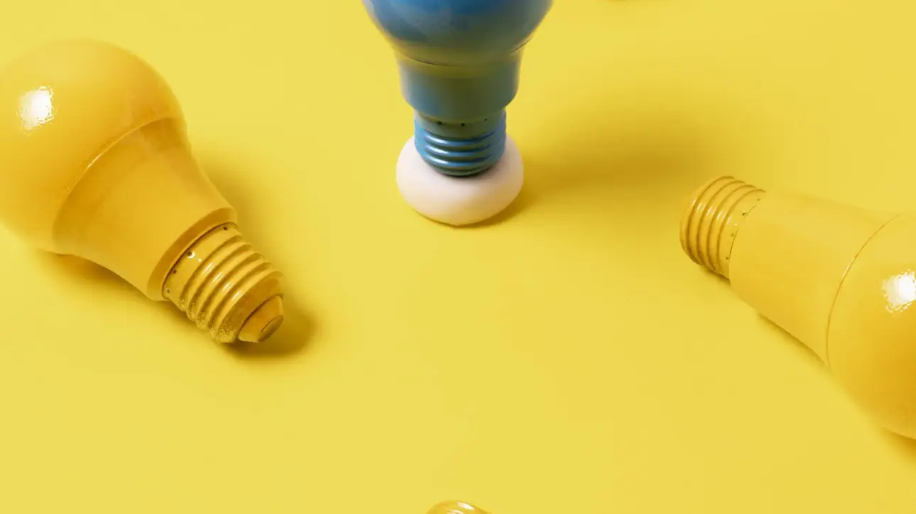 Imagem de lâmpadas amarelas e uma lâmpada azul ao centro, ilustrando como a consultoria de marketing é capaz de diferenciar a empresa