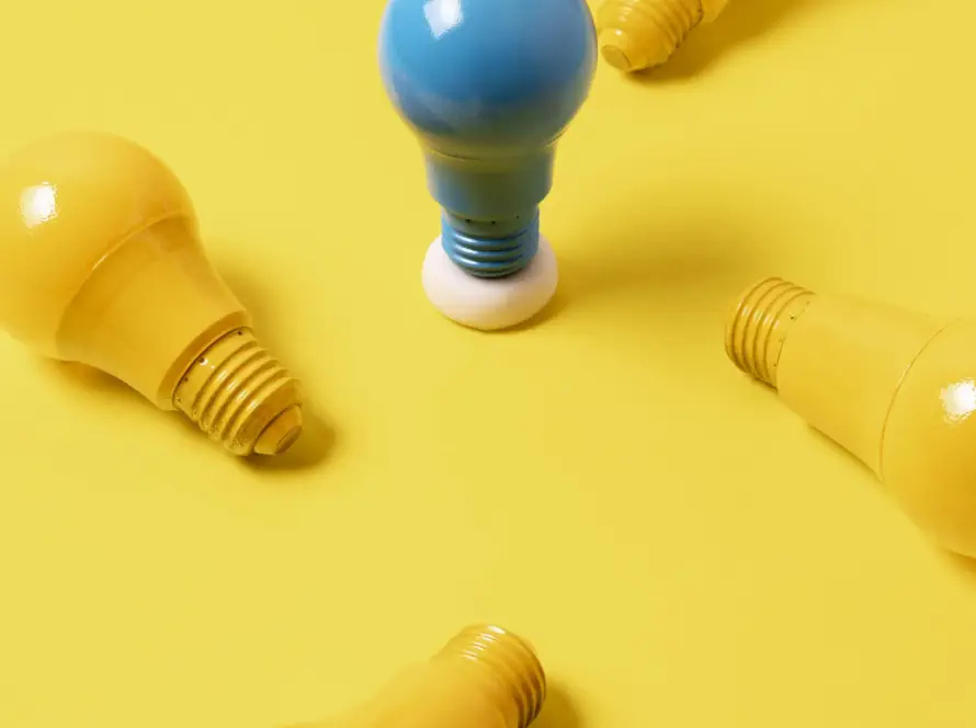 Imagem de lâmpadas amarelas e uma lâmpada azul ao centro, ilustrando como a consultoria de marketing é capaz de diferenciar a empresa